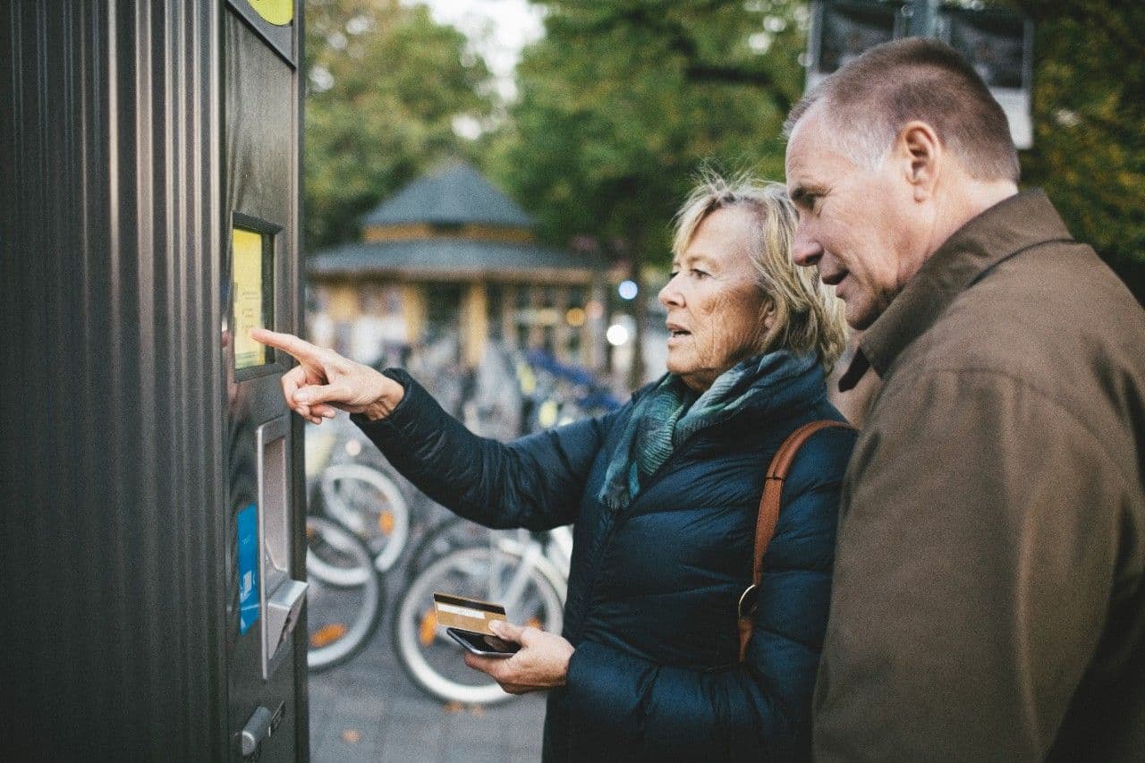 Woman pointing something out to man on screen
