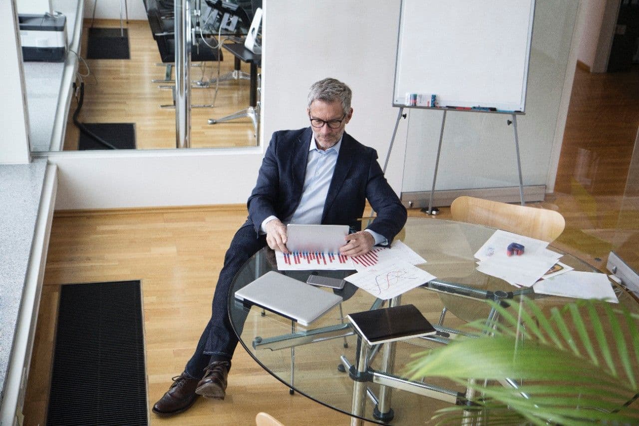 Man sitting at table looking over charts